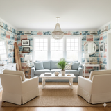 Boardwalk Ephemera Wallpaper featuring a collage pattern, with beachside images, on a wall in a styled living room.
