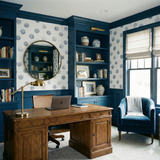 Patterned wallpaper with blue circles on white, textured with an uneven stamped look.
