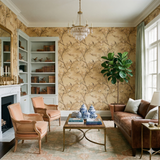 Golden aviary wallpaper with bird and floral pattern, styled in a traditionally decorated living room.
