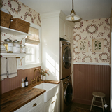 Floral patterned wallpaper featuring wreaths, branches and botanicals, with two botanical art prints.
