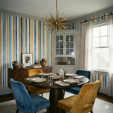 Marstrand Stripe Wallpaper with colorful vertical pattern and muted shades of blue, yellow, and gray.
