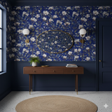 Floral wallpaper with white magnolias on dark blue by Sandberg adorned in an entryway with console table and round rug.
