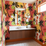 Tropical wallpaper with palm tree and citrus fruit design, on the walls of a bathroom.