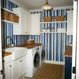Harbor stripe wallpaper with blue and white vertical lines, on a laundry room wall.