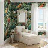 Crimson Chorus Wallpaper with tropical parrot pattern in a bright, verdant indoor setting.