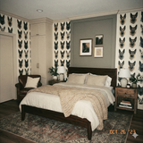 Facet Shepherd Wallpaper, patterned with geometric dog heads, with dog-themed bedroom decor.