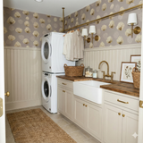 Beige and gold wallpaper with a reefburst pattern and neutral wainscoting.