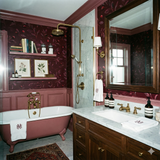 Floral wallpaper in red by Schumacher featuring a dense botanical pattern in a traditional bathroom.