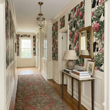 Patterned wallpaper with roses and dogs, a decorative print on a hallway wall.