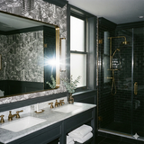Capitol Square Cluster wallpaper featuring a city-building pattern, with gray tones and decorative elements, displayed in a bathroom.