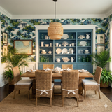 Tropical Conch House Reverie Wallpaper with trees and houses, covering the walls of a stylish dining room.
