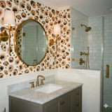 Savanna Ink wallpaper with brown and tan leopard print, covering the bathroom walls, complementing the gold mirror and sconces.