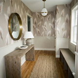 Fernshade pattern wallpaper with taupe-colored fronds and white accents, covering a hallway with wainscotting.