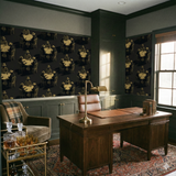 Black wallpaper with a poker game pattern, by York Wallcoverings, in a study with dark green trim.