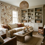 Arloix Herbarium Wallpaper with botanical leaf pattern, styled in a living room with a sofa, rug, and brown leather armchairs.
