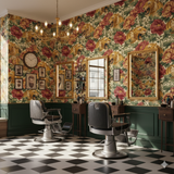 Floral and tiger patterned wallpaper with gold framed mirrors and black barber chairs.
