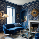 Midnight blue damask wallpaper with silver floral patterns, in a styled living room.
