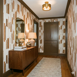 Switchgrass Fringe wallpaper with a vertical stripe pattern and brown accents, decorating a hallway with brown trim and wooden floors.