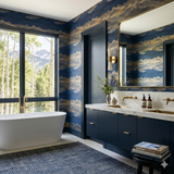 Blue and gold patterned wallpaper from Brewster Home Fashions, adorning a bathroom with a soaking tub and mountain view.
