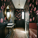 Patterned Atelier Nocturne Bliss Wallpaper with pink floral motif on black background.
