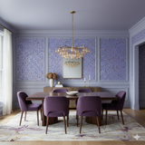 Confetti wallpaper with purple and gold floral pattern detailing, decorated with trim and molding, covering the wall in a styled dining room.
