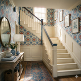 Patterned wallpaper with floral and geometric motifs, in blue, red, and cream tones.
