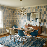 Mesa Ledger Wallpaper with blue and beige stripes pattern on the walls, behind dining room setup.