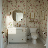 Floral Rosalyn Vine Wallpaper in a powder room with a white vanity and gold fixtures.