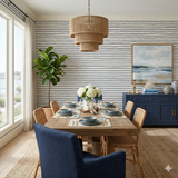 Navy striped Mariner’s Thread Wallpaper with a rope pattern, covering the walls in a coastal style dining room.
