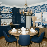 Blue rope-patterned wallpaper with navy wainscotting, adjacent to a dining table with place settings.