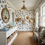 Beige Antiqua wallpaper with blue seashell pattern, from Blueport, on a sunroom wall with mirror, cabinet, and wooden bench.
