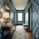 Blue patterned Saltaire Crest Wallpaper with white floral damask print, seen in a hallway setting.