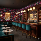 Floral wallpaper with peony pattern and vibrant hues, against dark trim and a bar area.