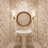 Vineyard Rosewalk Wallpaper featuring a climbing rose pattern in pink and green, covering walls and reflected in an ornate mirror.
