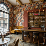 Printed Vérité Assemblage Wallpaper with repeating portrait collage pattern.
