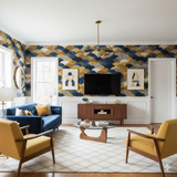 Gold and blue wave patterned wallpaper with white trim and a blue sofa in a styled living room.