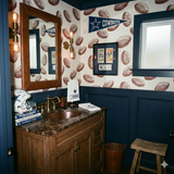 Printed Gridiron Etching Room Wallpaper with football pattern, covering a bathroom with wainscoting.
