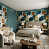 Patterned wallpaper with teal, brown, and white abstract shapes, from Tide & Tumble, in a styled bedroom setting.