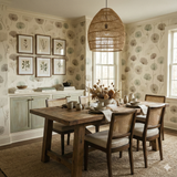 Larkspire Meadowdraft wallpaper with dandelion design, set in a dining room with wood table and tan rug.
