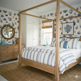 Patterned Blueport Antiqua Wallpaper with a seashell and coral print, used as wall decor in a bedroom.