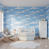 Blue sky wallpaper with white cloud pattern, evoking a cheerful nursery atmosphere.