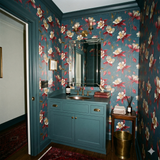 Floral wallpaper with crimson and white flowers with gold accents, patterned across a blue backdrop.