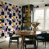 Patchwork Echo Wallpaper with geometric pattern, multicolored shapes on a cream textured background.