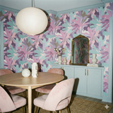 Field Fragment Wallpaper in multicolored floral pattern, covering walls in a styled dining room.

