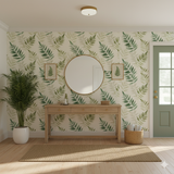 Verdant Fern Wallpaper with fern leaf pattern, decorating a neutral toned entryway with light wood furniture.
