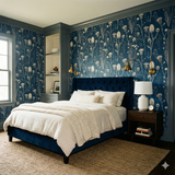 Saltmarsh Briar wallpaper with blue botanical pattern on the wall, styled in a bedroom scene.