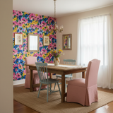 Floral Capri Garden Wallpaper with vibrant pinks, yellows and blues, with framed art and a chandelier.
