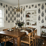 Botanical wallpaper with dark feather pattern on a light background, accenting a dining room.