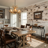 Patterned wallpaper featuring cows on a grassy landscape, with a framed painting and wooden dining set in a rustic dining room.