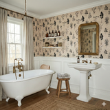 Botanical wallpaper with floral leaf pattern on beige background; two white shelves, and framed mirror in a styled bathroom.